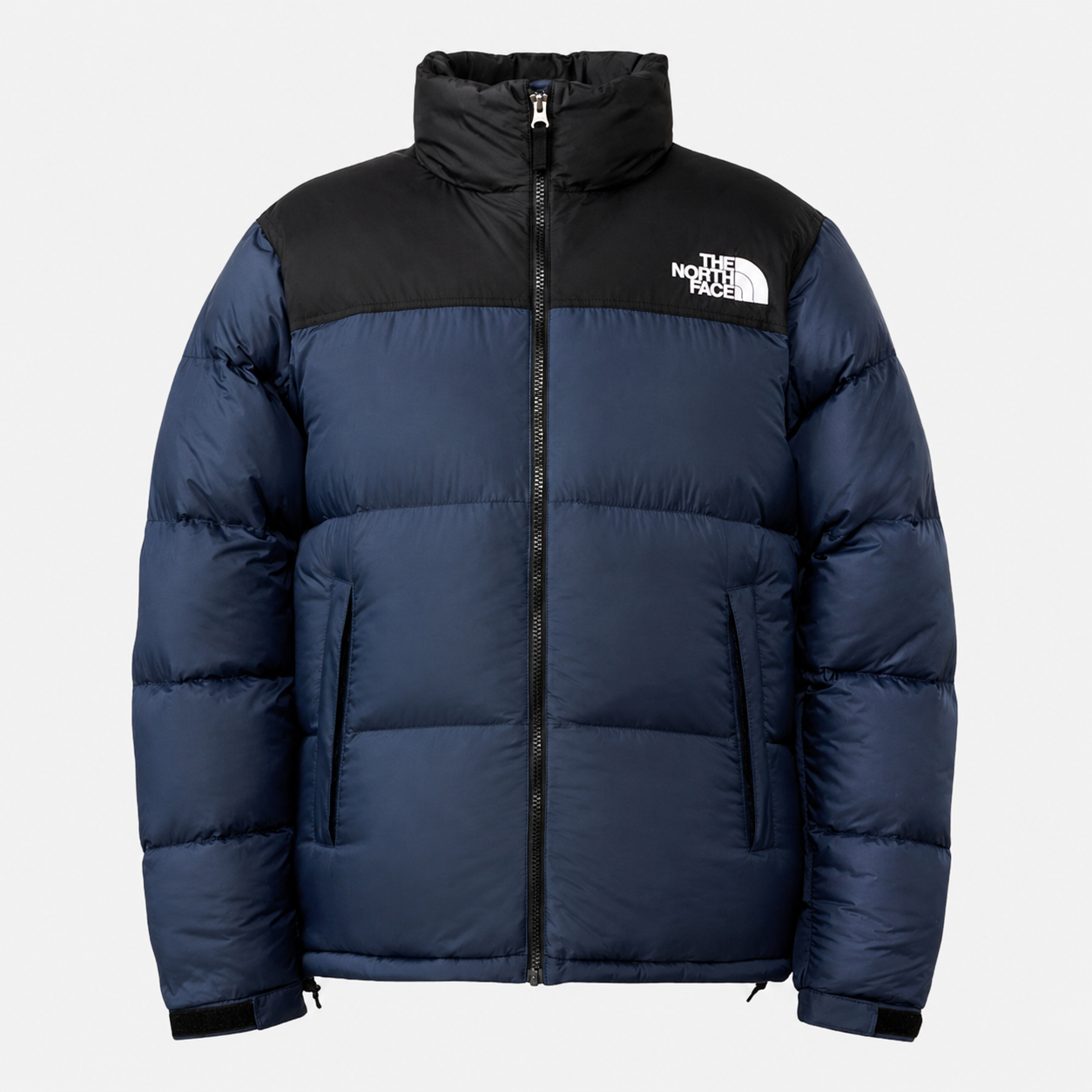 The-North-Face-Mens-1996-Retro-Nuptse-Jacket-Navy-Black (2) The North Face Men’s 1996 Retro Nuptse puffer jacket in navy blue and black with a high collar, full-zip front, hand pockets and white chest logo.